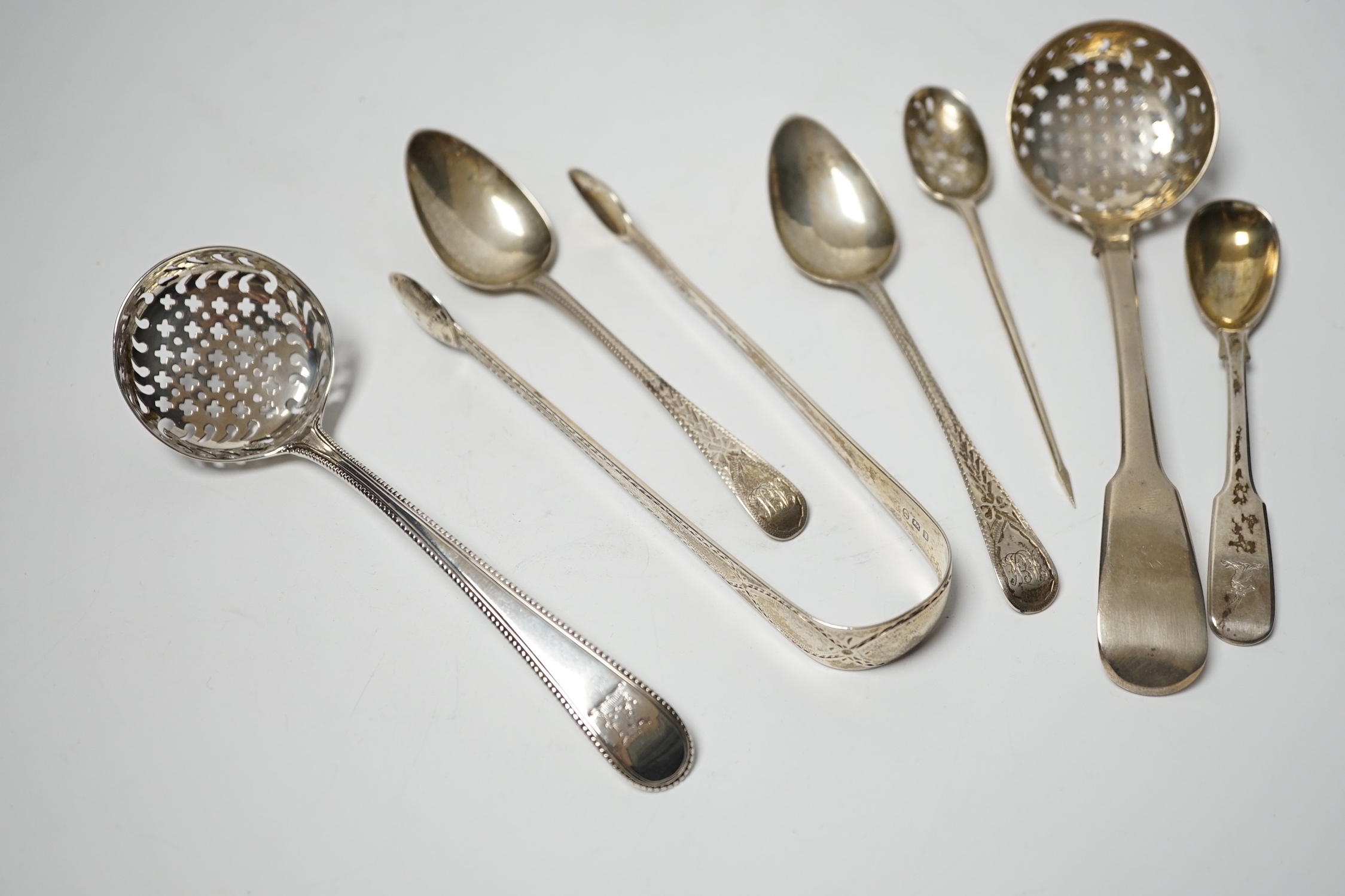 An 18th century silver mote spoon, marks rubbed, 11.8cm and five other various silver spoons and a pair of silver sugar tongs, 5.1oz.